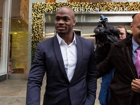 Suspended Minnesota Vikings running back Adrian Peterson (L) exits following his hearing against the NFL over his punishment for child abuse, in  New York December 2, 2014. (REUTERS/Brendan McDermid)