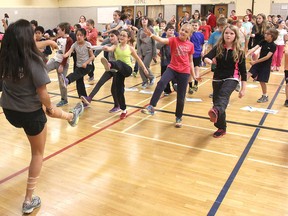 Students from the Fitness Leadership program at La Salle Secondary School lead Grades 4-6 students from Sir John A. Macdonald Public School in a warm-up prior to testing their fitness on Dec. 10. (Michael Lea/The Whig-Standard).