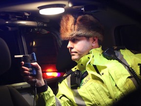 Airdrie, Alta. - Cpl. Darren Turnbull with a breathalyzer in his vehicle as Airdrie RCMP and Calgary Police hold a check stop along Township Road 566 in Balzac on Friday, Dec. 5, 2014. BRITTON LEDINGHAM / AIRDRIE ECHO