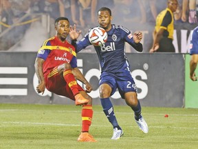 Real Salt Lake’s Robbie Findley (left) kicks the ball over a Vancouver defender during a game this season. Findley was taken by TFC in the re-entry draft. (USA TODAY SPORTS)