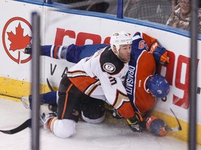 Edmonton centre Leon Draisaitl (29) is hit against the boards by Anaheim defenceman Clayton Stoner (3) during the third period of a NHL hockey game between the Edmonton Oilers and Anaheim Ducks at Rexall Place in Edmonton, Alta., on Friday, Dec. 12, 2014. The Ducks won 4-2. Ian Kucerak/Edmonton Sun/ QMI Agency