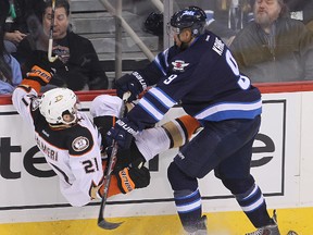 Anaheim Ducks right winger Kyle Palmieri (l) is dumped by Winnipeg Jets left winger Evander Kane  during NHL hockey in Winnipeg, Man. Sunday, Dec. 07, 2014.