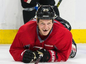 Ottawa Senators Chris Neil smiles after being knocked to the ice during team practice at the Canadian Tire Centre in Ottawa on Tuesday, Dec. 9, 2014. (Errol McGihon/Ottawa Sun/QMI Agency)