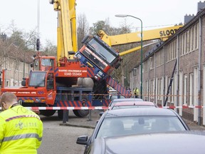 A picture taken on December 13, 2014 in IJsselstein shows a crane which fell down on to the roof of a house. The incident occurred when a man tried to surprise his girlfriend by proposing from the top of the crane, which then toppled on to the house, though no injuries were reported. (AFP PHOTO/ANP/GINOPRESS)