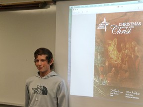 Shane Mozden stands next to a projection of his winning graphic design project which will be sent out by the Kenora Catholic District School Board as their Christmas greeting.