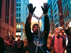 A man with a chain on his body takes part in a march against police violence, in New York December 13, 2014. Thousands marched in Washington, New York and Boston on Saturday to protest killings of unarmed black men by police officers. (REUTERS/Eduardo Munoz)