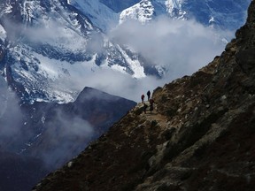 Trekkers walk in front of Mount Thamserku while on their way back from Everest base camp at Pheriche, approximately 4,300 meters above sea level, in Solukhumbu District May 3, 2014. REUTERS/Navesh Chitrakar