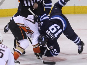 Winnipeg Jets centre Jim Slater (right) goes airborne in the face-off circle against Anaheim Ducks centre Ryan Kesler during NHL action at MTS Centre in Winnipeg, Man., on Sat., Dec. 13, 2014. (Kevin King/Winnipeg Sun/QMI Agency)