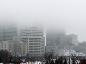 The skyline of downtown Winnipeg, Man. is partially obscured by mist and drizzle as temperatures hovered around the freezing point Sunday December 14, 2014.(Brian Donogh/Winnipeg Sun/QMI Agency)