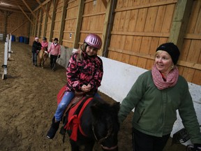 Hannah Gjelstad goes for a pony ride during a Gleaners Food Bank fundraiser held at Flat Rock Farm. Jason Miller/ The Intelligencer