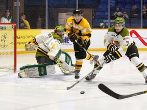 ​Kingston Frontenacs' Corey Pawley (92) cuts through the North Bay Battalion crease after goalie Jake Smith directed the puck wide with defenceman Miles Liberati (7) applying pressure during first-period Ontario Hockey League action at Memorial Gardens in North Bay on Sunday. (Dave Dale/QMI Agency)