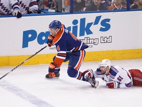 Edmonton forward Taylor Hall (4) is taken down by New York forward Rick Nash (61) during the second period of a NHL hockey game between the Edmonton Oilers and New York Rangers at Rexall Place in Edmonton, Alta., on Sunday, Dec. 14, 2014. Ian Kucerak/Edmonton Sun/ QMI Agency