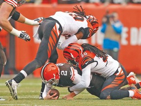 Browns’ Johnny Manziel gets taken down by Cincinnati Bengals’ Reggie Nelson (right) and Emmanuel Lamur on Sunday. (USA TODAY SPORTS)