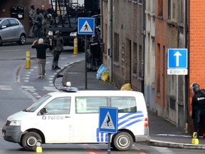 A suspected hostage taker, left, surrenders to Belgian police after four armed men invaded an apartment in the city of Ghent on December 15, 2014. (AFP PHOTO/BELGA/NICOLAS MAETERLINCK)