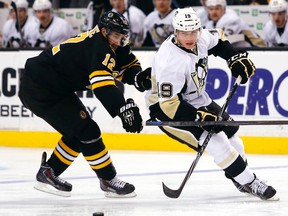 Pittsburgh Penguins right wing Beau Bennett (19) and Boston Bruins left wing Simon Gagne (12) eye a loose puck during the third period of the Pittsburgh Penguins 3-2 overtime win at TD Garden on Nov 24, 2014 in Boston, MA, USA. (Winslow Townson/USA TODAY Sports)