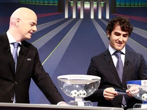 UEFA General Secretary Gianni Infantino (left) stands next to Karl-Heinz Riedle, ambassador for the UEFA Champions League final in Berlin, as they conduct the draw for the Champions League round of 16 at UEFA headquarters in Nyon December 15, 2014. (REUTERS/Pierre Albouy)