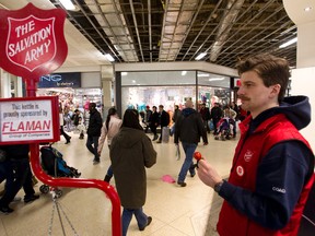 Alex Williams collects donations at a Salvation Army kettle as shoppers by at West Edmonton Mall in Edmonton, Alta., on Saturday, December 22, 2012. Wiliams is volunteering in the kettle campaign for his fourth time. Ian Kucerak/Edmonton Sun