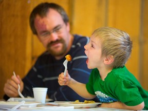 Nicholas Blois, 4, makes sure he has room for another piece of pancake as his dad, Keith, looks on, at Fanshawe Pioneer Village?s Breakfast with St. Nicholas, at Fanshawe Conservation Area. (MIKE HENSEN, The London Free Press)
