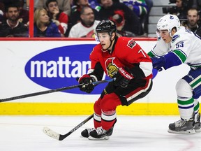 Ottawa Senators forward Kyle Turris moves the puck away from Vancouver Canucks forward Bo Horvat during NHL action at the Canadian Tire Centre in Ottawa Sunday December 7, 2014. (Errol McGihon/Ottawa Sun/QMI Agency