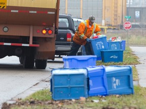 A worker collects blue-box items along Oak St. in London Monday. (CRAIG GLOVER, The London Free Press)