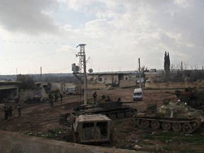 Rebel fighters stand near tanks inside al-Hamidiyeh base, one of two military posts they took control of from forces loyal to Syria's President Bashar al-Assad in the northwestern province of Idlib on December 15, 2014. (REUTERS/Stringer)