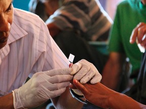 A government health worker takes a blood sample to be tested for malaria in Ta Gay Laung village hall in Hpa-An district in Kayin state, south-eastern Myanmar, November 28, 2014. (REUTERS/Astrid Zweynert)