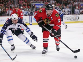 Duncan Keith #2 of the Chicago Blackhawks controls the puck under pressure from Mark Stuart #5 of the Winnipeg Jets at the United Center on November 2, 2014 in Chicago, Illinois. (Jonathan Daniel/Getty Images/AFP)