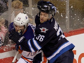 Edmonton Oilers left winger Curtis Hamilton is tied up by Winnipeg Jets defenceman Josh Morrissey during a game at the MTS Centre on September 24, 2014. (Brian Donogh/Winnipeg Sun/QMI Agency)
