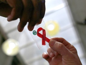 A nurse (L) hands out a red ribbon to a woman, to mark World Aids Day, at the entrance of Emilio Ribas Hospital, in Sao Paulo December 1, 2014.
REUTERS/Nacho Doce