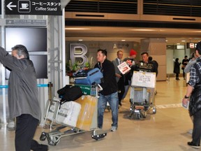 Passengers on an American Airlines flight that left South Korea's Incheon International Airport bound for Dallas in the United States, arrive after it made an emergency landing at Narita international airport, east of Tokyo, in this photo taken by Kyodo on December 17, 2014. (REUTERS/Kyodo)