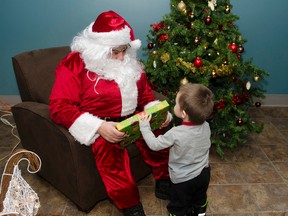 Noah Dubé bravely collects his gift from Santa Claus during the Ice Hut Christmas event held on Sunday. Children were able to visit with Santa and get a free gift thanks to The Ice Hut and HB White.