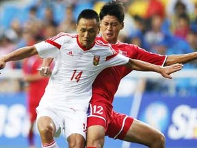 North Korea's Ri Yong Jik (R) challenges China's Chang Feiya during their men's soccer qualifier match for the 17th Asian Games at Incheon Football Stadium in Incheon September 15, 2014. (REUTERS)