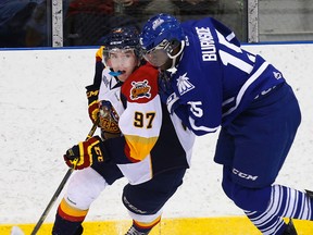 Connor McDavid of the Erie Otters tries to get around Mississauga Steelheads forward Damian Bourne during OHL preseason play in Oakville Sunday September 14, 2014. (Craig Robertson/Toronto Sun/QMI Agency)