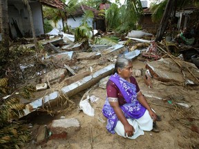 A Sri Lankan woman sits in front of her destroyed house in Kalmunai in this December 30, 2004 file photo. On December 26, 2004, a magnitude 9.15 quake off the coast of Indonesia's Aceh province triggered an Indian Ocean tsunami that killed around 226,000 people in Indonesia, Sri Lanka, India, Thailand and nine other countries. (REUTERS/Thomas White/Files)