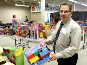 David Dickinson, executive director of Community and Family Services for the Salvation Army in Alberta and the NWT, admires a plastic train donated as part of the Adopt-a-Teen program.