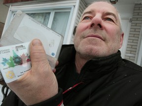 Denis Chretien holds a found Parliament Hill pass outside his home in Ottawa Tuesday, Dec. 17,  2014. Chretien found the pass in the snow on Halifax Drive in Ottawa. When he called security on the Hill, they told him to drop it into the mail.   (Tony Caldwell/Ottawa Sun/QMI Agency)