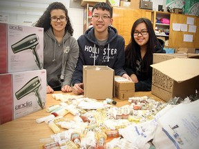 Sisler High grade 11 students (l-r) Ashley Amaral, Calvin Loi and Mae Anne Bathan display hygiene products that their group H.O.P.E. for the Homeless has collected in Winnipeg, Man. Wednesday December 17, 2014. The items will be donated to Siloam Mission.