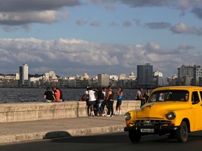 Youth sit on Havana's El Malecon seafront bolulevard December 17, 2014.   REUTERS/Enrique De La Osa