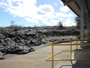 Lava flow from the Kilauea volcano is pictured having breached a fence but stopped feet away from a transfer station outside the village of Pahoa on Hawaii's Big Island December 8, 2014. The slow-moving lava flow from an erupting volcano on Hawaii's Big Island incinerated a house last month, marking the first home devoured by a stream of molten rock that has crept toward the village of Pahoa for weeks, civil defense officials said. The home had been evacuated some time ago, and no injuries were reported from the river of lava, which began oozing from Kilauea Volcano in late June. Hawaii County Civil Defense officials said no other dwellings were immediately threatened. REUTERS/Karin Stanton