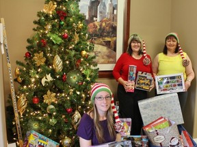 Midhaven Homes collected over 200 gifts for a Christmas Toy Drive, new home owners gave generously to the cause. From left: Midhaven's Kristina Petrie, new Midhaven home owner Vicki Johnson, and Midhaven's Rebecca Evans prepare to wrap and deliver the toys.