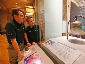 Parks Canada archeologist divers Ryan Harris and Jonathan Moore (r) have a look at a replica of the actual bell they found aboard the sunken ship of John Franklin in the Arctic last summer. The Royal Ontario Museum announced they will be displaying a 3D replica of the bell found on the Erebus, John Franklin's shop that sunk 160 years ago, as part of a three year project on the Franklin finds. on Thursday December 18, 2014. (Michael Peake/Toronto Sun)