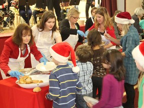 Children line up for their holiday meal as volunteers serve up turkey and all the trimmings at Frontenac Public School on Thursday, Dec.18, 2014. MICHAEL LEA/THE WHIG STANDARD