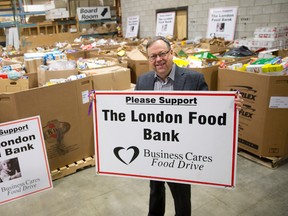 Business Cares Food Drive committee member Wayne Dunn, who is hoping support for the annual food drive will increase significantly in the final days, holds up a sign while standing with some of the food donations received so far at County Heritage Thursday. Organizers have only raised approximately 40% of their 281,000-pound goal so far. CRAIG GLOVER The London Free Press / QMI AGENCY