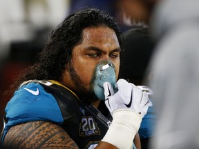 Jaguars player Tyson Alualu uses an oxygen mask on the sideline during fourth quarter NFL action against the Titans in Jacksonville, Fla., on Thursday, Dec. 18, 2014. (Sam Greenwood/Getty Images/AFP)