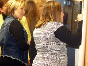 Former Wallaceburg Childcare and Learning Centre student Carmella Lamont signs a sheet saying goodbye to staff while her grandmother Carmen McGregor looks on, at an open house held at the facility on Dec. 22. The Childcare and Learning Centre is getting new operators in a cost-cutting move.