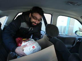 Osman Naqvi puts a turkey into one of the Christmas hampers he delivered Friday as part of the Caring and Sharing Exchange. More than 400 hampers were packed and distributed and thousands more will receive food vouchers.
DOUG HEMPSTEAD/Ottawa Sun