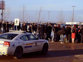 Passengers wait outside in the cold after the Fort McMurray International Airport was evacuated due to a passenger's comments about a bomb. (MICHELLE ALLENBERG/QMI Agency)