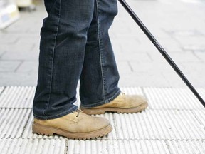 Blind man using a walking cane. 

(Fotolia)