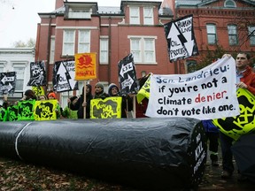 Climate advocates and representatives from the Rosebud Sioux Tribe in South Dakota protest against the Keystone XL pipeline in front of the home (center) of U.S. Senator Mary Landrieu (D-LA), chair of the Senate Energy Committee, in Washington November 17, 2014. A Democratic leader said on Sunday a single vote could determine the fate of the Keystone XL pipeline in the U.S. Senate this week but that President Barack Obama was likely to veto the bill even if it passes.  REUTERS/Gary Cameron