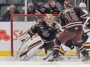 Kingston Frontenacs’ Ryan Verbeek tries to tip the bouncing puck past Peterborough Petes goaltender Dylan Wells as the Petes’ Steven Lorentz looks on during the first period of Ontario Hockey League action at the Rogers K-Rock Centre on Friday night. The Petes won 3-1, handing the Frontenacs their fifth consecutive loss. (Julia McKay/The Whig-Standard)